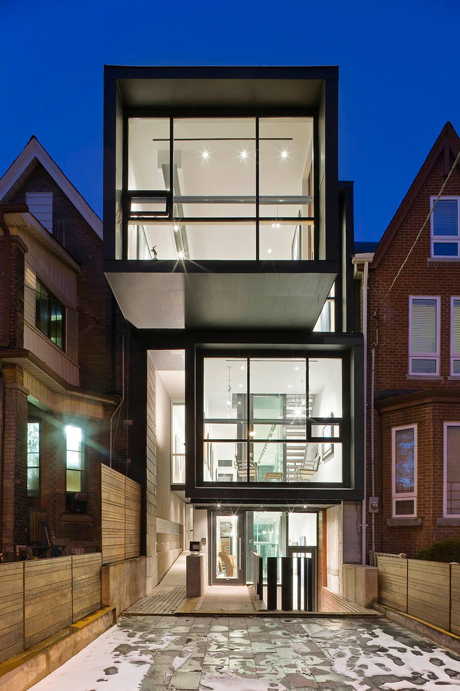 Photo of a contemporary three-storey exterior in Toronto with mixed siding and a flat roof.