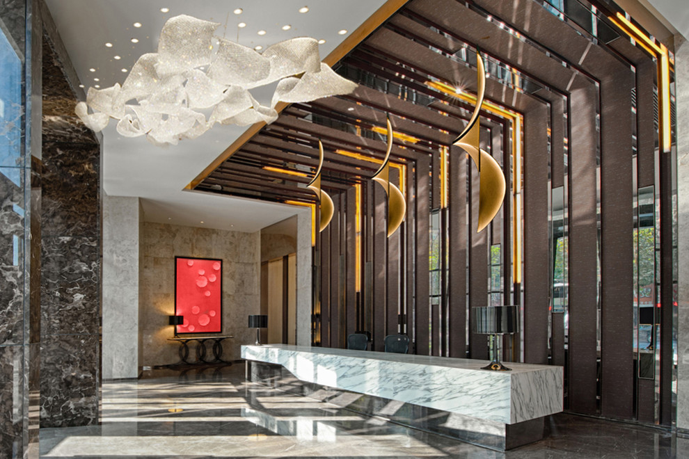 Example of a large trendy marble floor and beige floor hallway design in Miami with beige walls