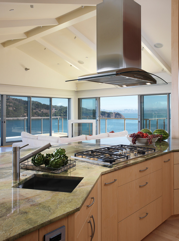 This is an example of a mid-sized contemporary single-wall eat-in kitchen in San Francisco with an undermount sink, flat-panel cabinets, light wood cabinets, granite benchtops, green splashback, stone slab splashback, stainless steel appliances, light hardwood floors and with island.