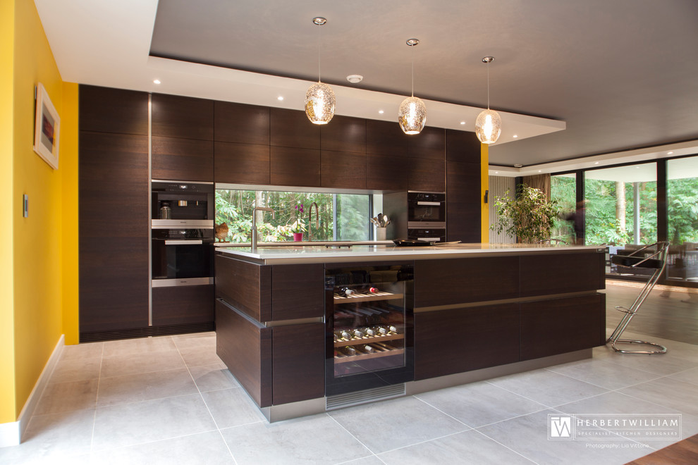 Design ideas for a large contemporary l-shaped open plan kitchen in Hampshire with a single-bowl sink, recessed-panel cabinets, dark wood cabinets, quartzite benchtops, stainless steel appliances and a peninsula.