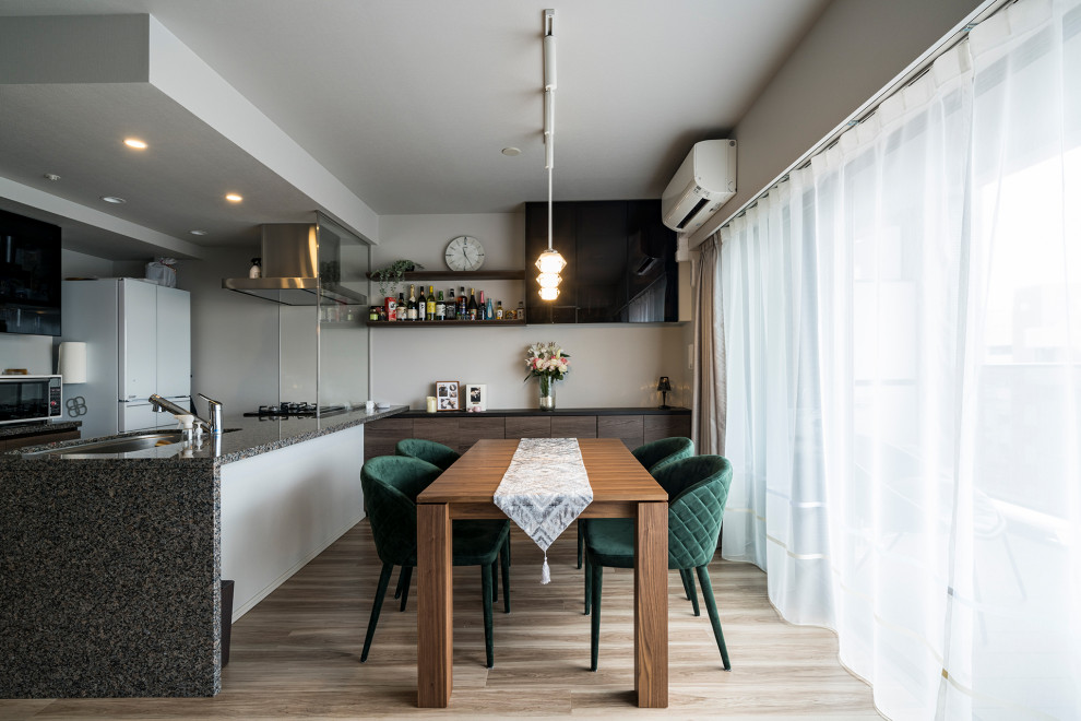Aménagement d'une salle à manger moderne de taille moyenne avec un mur blanc, parquet clair et éclairage.