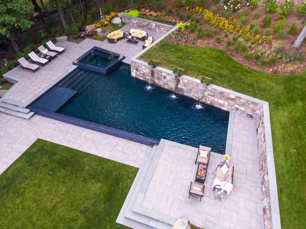 Photo of a large contemporary backyard l-shaped aboveground pool in New York with tile.