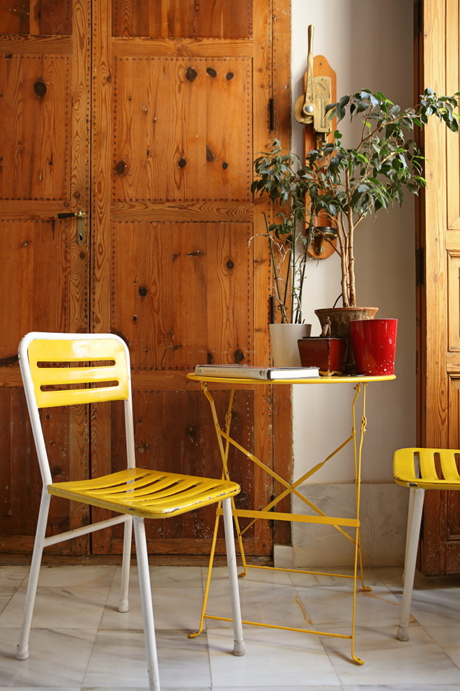 Imagen de sala de estar abierta mediterránea pequeña sin chimenea y televisor con paredes blancas y suelo de mármol
