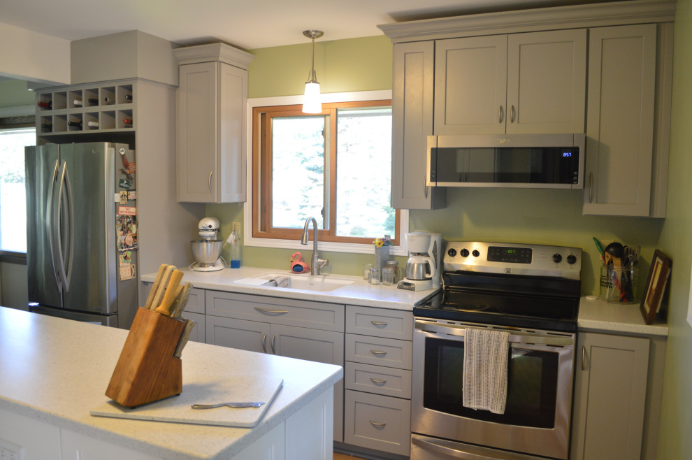 Inspiration for a small transitional single-wall vinyl floor eat-in kitchen remodel with an undermount sink, shaker cabinets, gray cabinets, solid surface countertops, stainless steel appliances, an island and white countertops