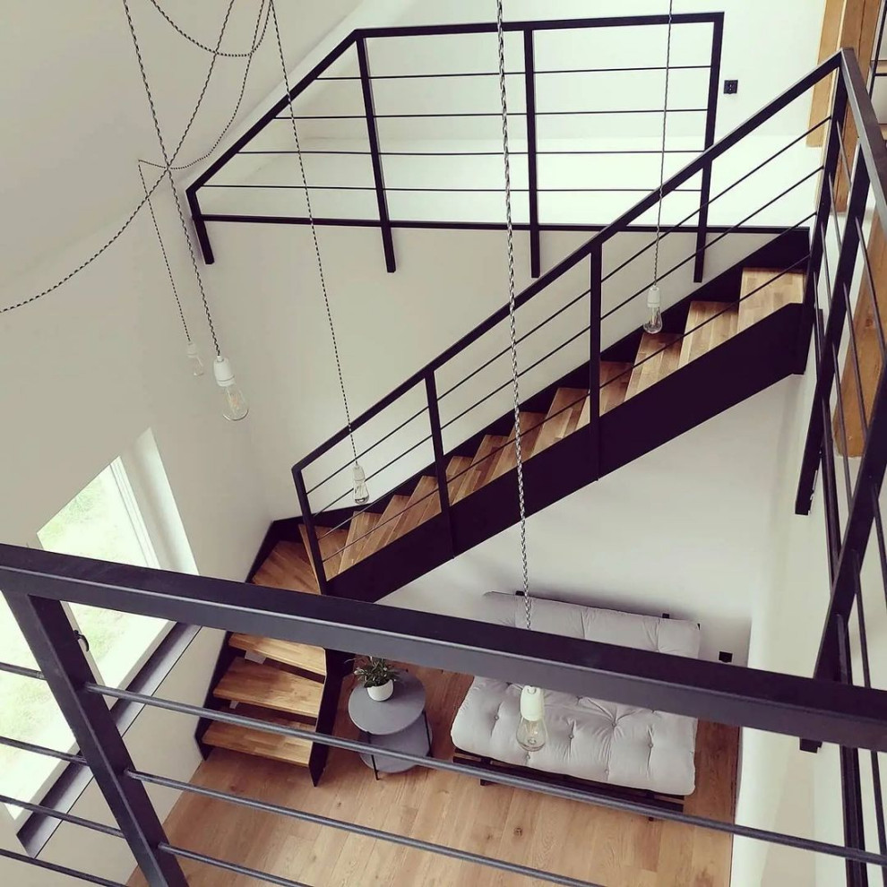 Photo of a mid-sized industrial wood l-shaped staircase in Moscow with wood risers and metal railing.