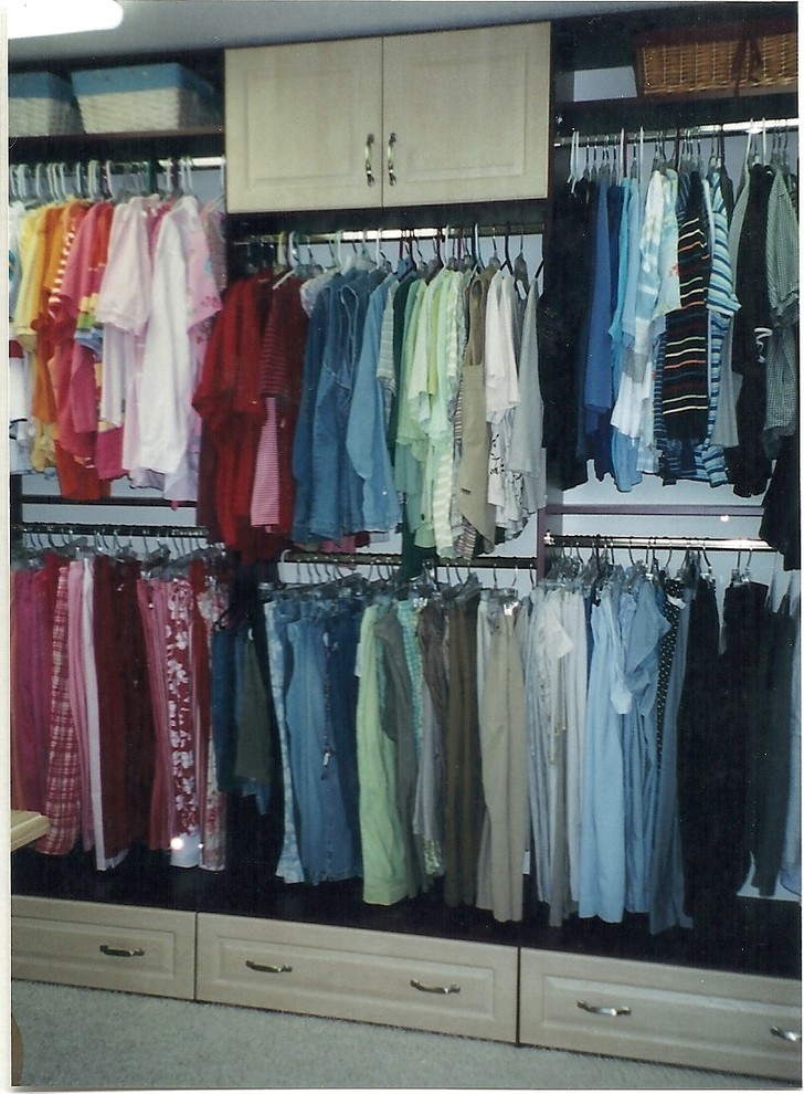 Imagen de armario vestidor actual grande con armarios con paneles con relieve, puertas de armario de madera clara y moqueta