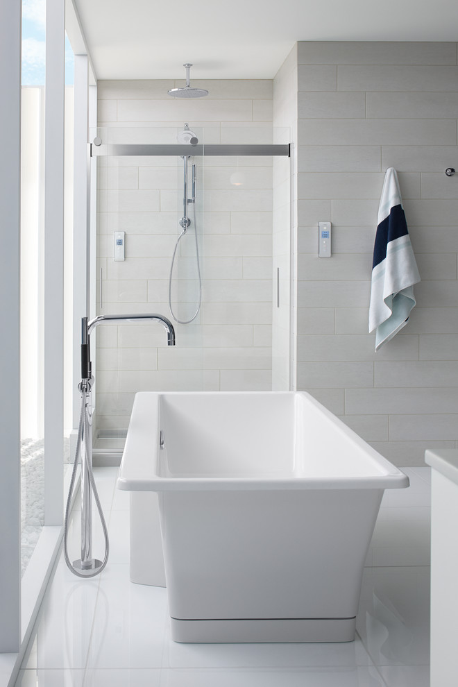 Design ideas for a large contemporary master bathroom in Milwaukee with a freestanding tub, an alcove shower, white tile, grey walls and marble floors.