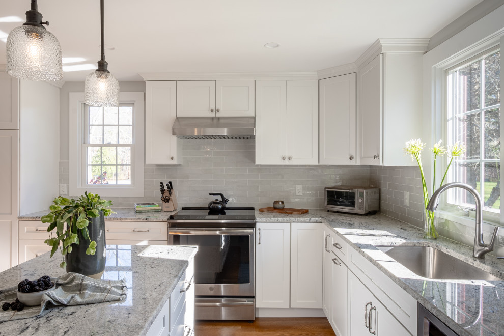 Example of a transitional medium tone wood floor eat-in kitchen design in Boston with an undermount sink, shaker cabinets, white cabinets, granite countertops, blue backsplash, porcelain backsplash, stainless steel appliances, an island and gray countertops