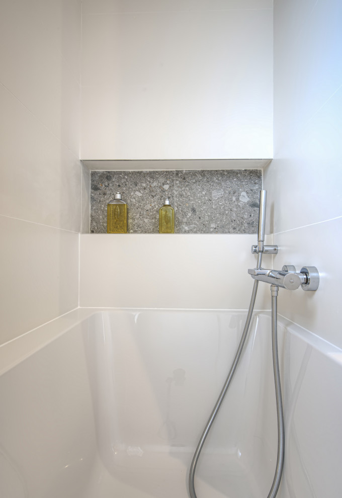 Inspiration for a large modern master gray tile and terra-cotta tile gray floor and double-sink bathroom remodel in Montpellier with an undermount tub, white walls, a console sink, white countertops, a niche and a wall-mount toilet