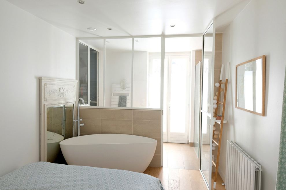 Small scandinavian bathroom in Paris with a drop-in tub, beige tile, beige walls and light hardwood floors.