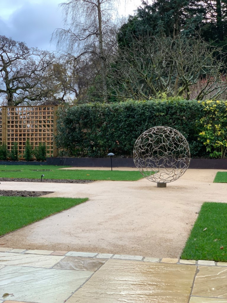 Foto di un grande giardino minimalista esposto in pieno sole dietro casa in estate con pavimentazioni in pietra naturale e recinzione in legno