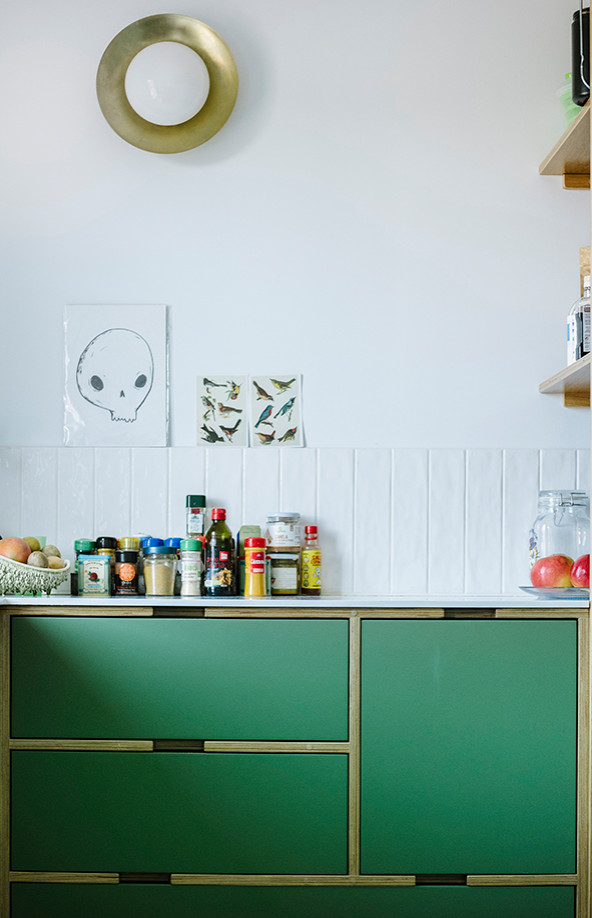 Foto på ett minimalistiskt vit kök, med gröna skåp, bänkskiva i kvarts, rostfria vitvaror, betonggolv och grått golv