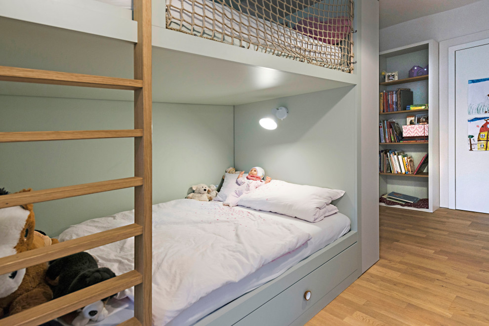 This is an example of a large contemporary children’s room for girls in Other with green walls, medium hardwood flooring and brown floors.