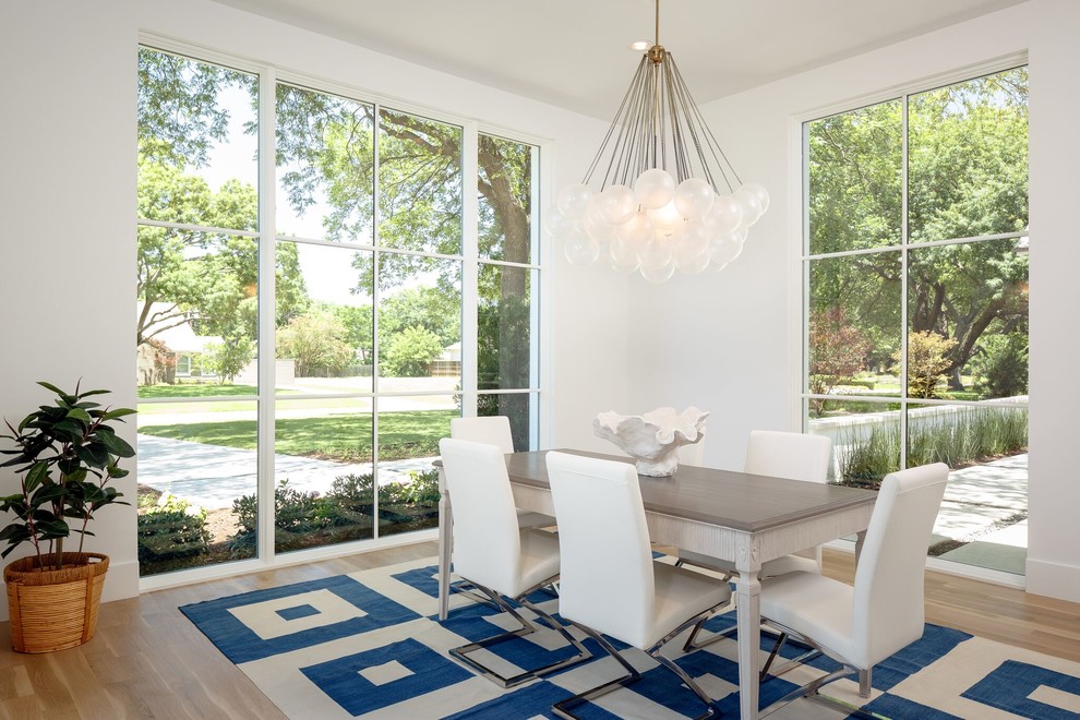 Photo of a mid-sized beach style separate dining room in Dallas with white walls, light hardwood floors, no fireplace and beige floor.