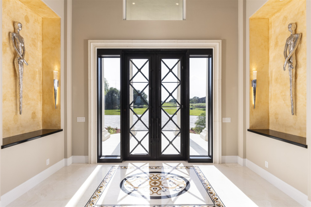 Réalisation d'un très grand hall d'entrée design avec un mur beige, un sol en marbre, une porte double, une porte en verre, un sol multicolore et un plafond voûté.