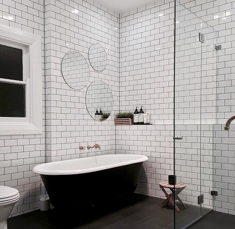 Design ideas for a mid-sized eclectic master bathroom in Sydney with flat-panel cabinets, medium wood cabinets, a freestanding tub, a curbless shower, a one-piece toilet, white tile, subway tile, white walls, ceramic floors, a console sink, wood benchtops, black floor and a hinged shower door.