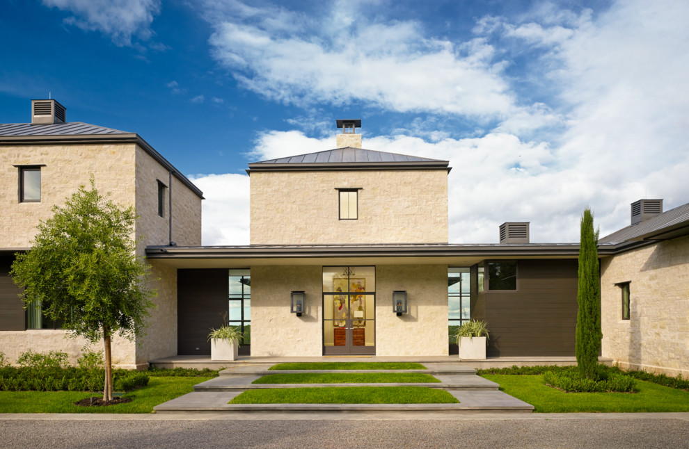 This is an example of a transitional two-storey beige exterior in Austin with stone veneer.