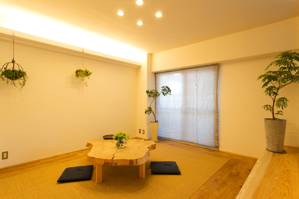 This is an example of an asian living room in Yokohama with white walls, medium hardwood floors and brown floor.