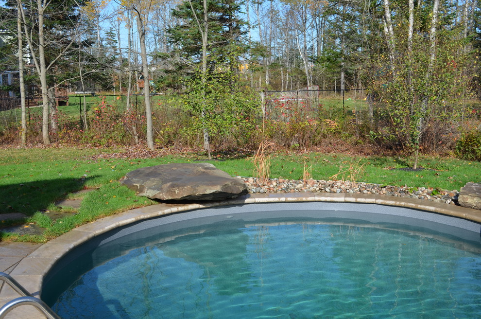Design ideas for a large country backyard natural pool in Other with natural stone pavers.