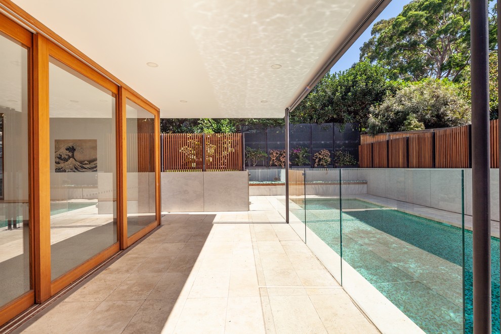 This is an example of a mid-sized contemporary two-storey white house exterior in Sydney with concrete fiberboard siding, a flat roof and a metal roof.