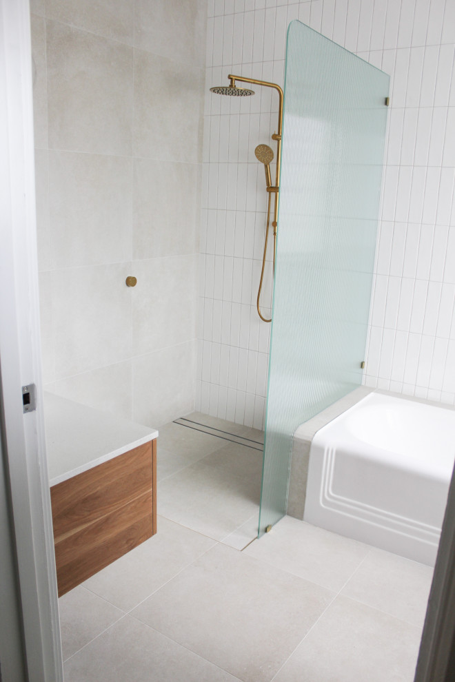 Пример оригинального дизайна: большая главная ванная комната в современном стиле с плоскими фасадами, темными деревянными фасадами, полновстраиваемой ванной, открытым душем, унитазом-моноблоком, белой плиткой, керамической плиткой, белыми стенами, полом из керамогранита, настольной раковиной, столешницей из искусственного кварца, серым полом, открытым душем, белой столешницей, тумбой под одну раковину и подвесной тумбой