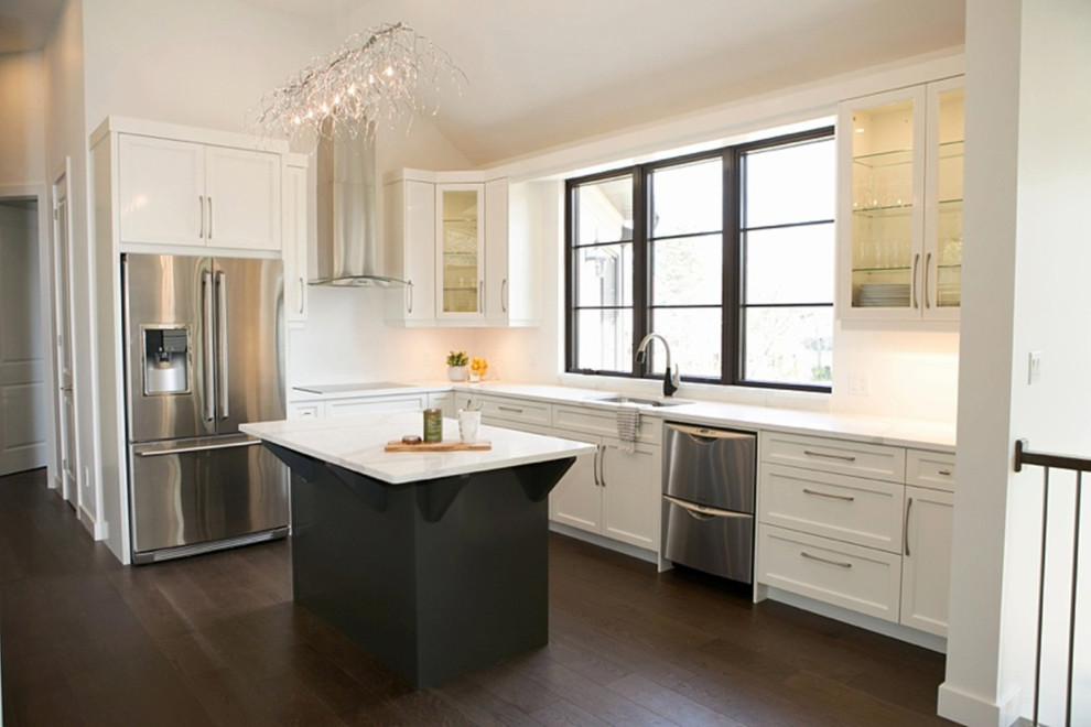 Inspiration for a mid-sized transitional l-shaped open plan kitchen in Toronto with a double-bowl sink, recessed-panel cabinets, white cabinets, marble benchtops, white splashback, stainless steel appliances, dark hardwood floors, with island and brown floor.