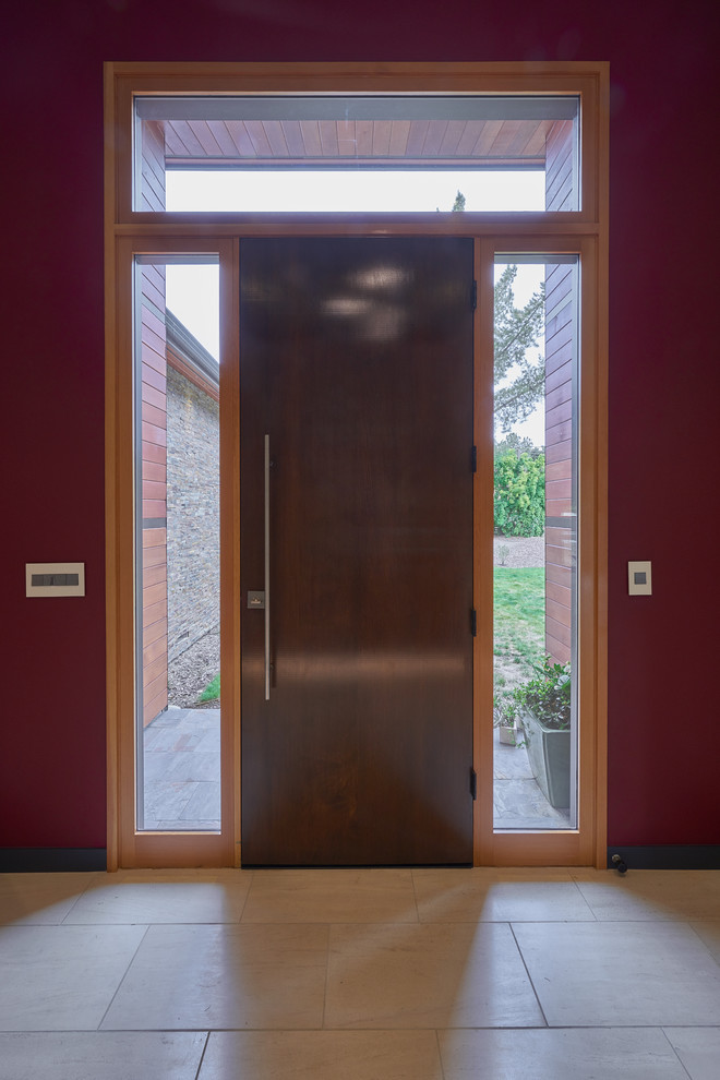 This is an example of a large modern foyer in San Francisco with multi-coloured walls, a single front door, a dark wood front door, laminate floors and beige floor.