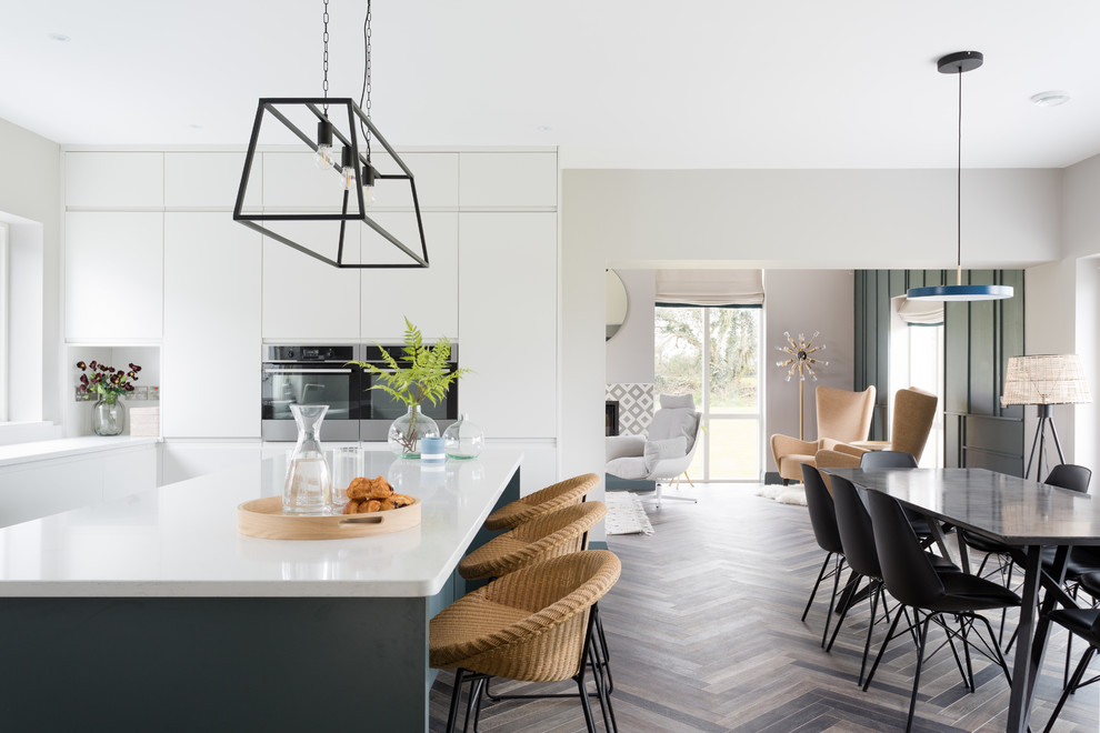 Inspiration for a large contemporary l-shaped eat-in kitchen in Cork with an undermount sink, flat-panel cabinets, grey cabinets, quartzite benchtops, white splashback, glass sheet splashback, stainless steel appliances, ceramic floors, with island, brown floor and white benchtop.