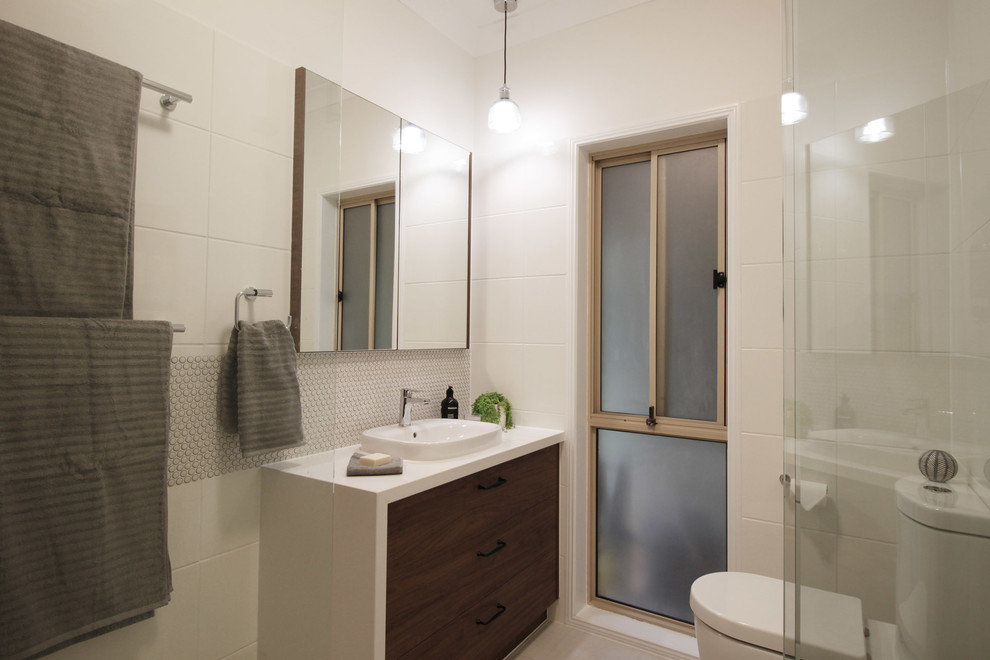 Photo of a small contemporary master bathroom in Brisbane with flat-panel cabinets, dark wood cabinets, an alcove shower, a two-piece toilet, white tile, ceramic tile, white walls, porcelain floors, engineered quartz benchtops, beige floor, a hinged shower door and white benchtops.