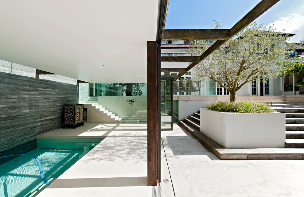 Photo of a contemporary backyard rectangular lap pool in London.