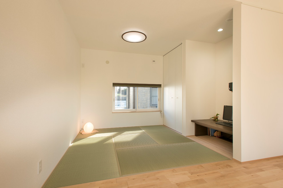 This is an example of an asian family room in Nagoya with white walls, tatami floors and white floor.