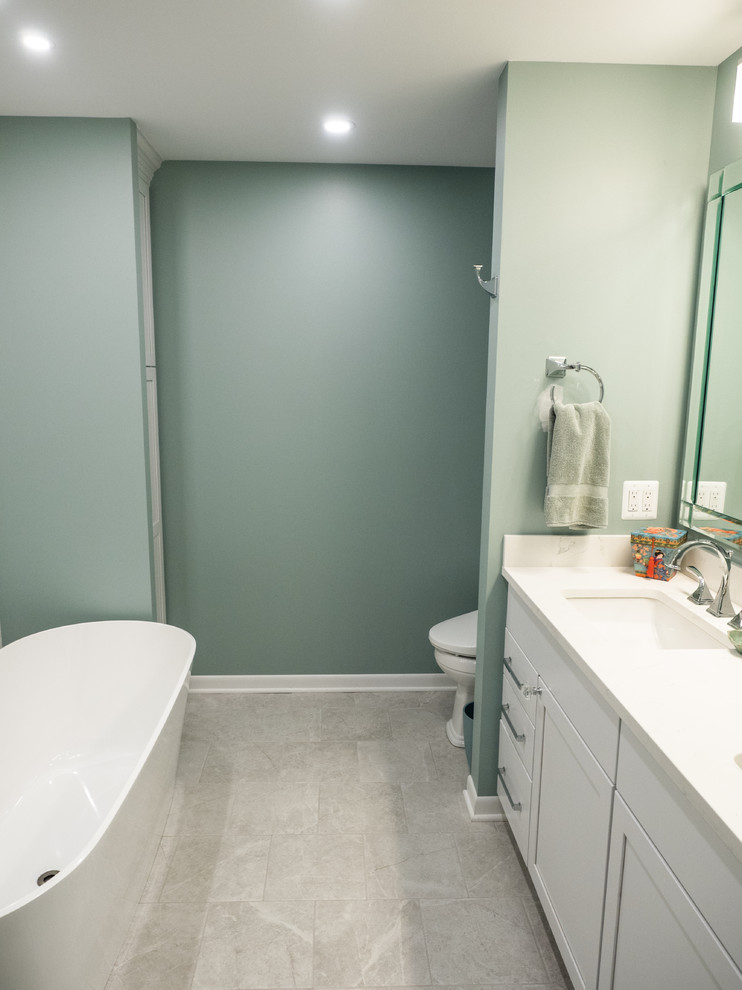 Freestanding bathtub - mid-sized transitional master multicolored tile and ceramic tile ceramic tile and gray floor freestanding bathtub idea with furniture-like cabinets, white cabinets, a two-piece toilet, white walls, an undermount sink, quartz countertops and a hinged shower door