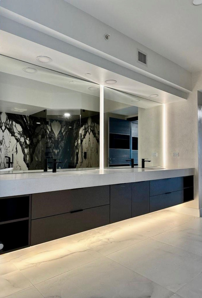 Photo of a large modern ensuite bathroom in Miami with flat-panel cabinets, dark wood cabinets, a freestanding bath, black and white tiles, stone slabs, porcelain flooring, a submerged sink, white floors, a hinged door, white worktops, double sinks, a floating vanity unit and engineered stone worktops.