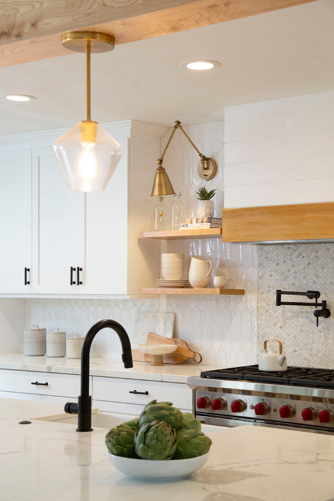 Inspiration for a mid-sized transitional galley eat-in kitchen in San Diego with a farmhouse sink, shaker cabinets, white cabinets, quartz benchtops, white splashback, mosaic tile splashback, stainless steel appliances, light hardwood floors, with island, beige floor and white benchtop.