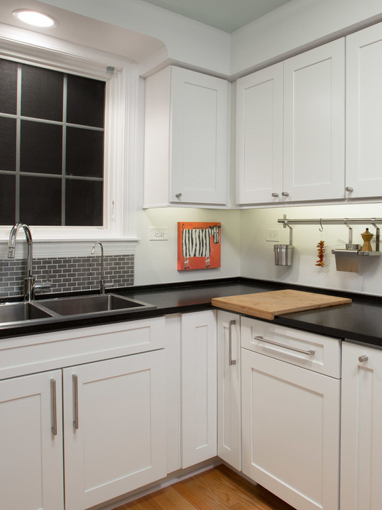 Inspiration for a mid-sized transitional u-shaped medium tone wood floor enclosed kitchen remodel in Chicago with a double-bowl sink, shaker cabinets, white cabinets, quartzite countertops, gray backsplash, subway tile backsplash, stainless steel appliances and no island