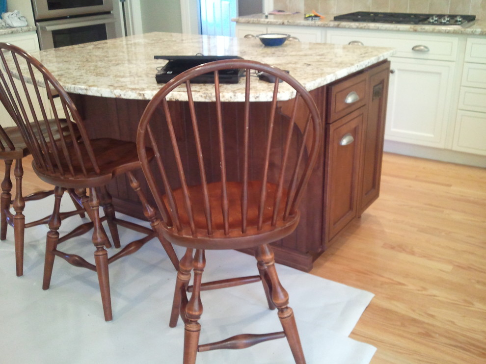 Transitional u-shaped light wood floor eat-in kitchen photo in Boston with an undermount sink, shaker cabinets, white cabinets, quartz countertops, beige backsplash, stainless steel appliances and an island
