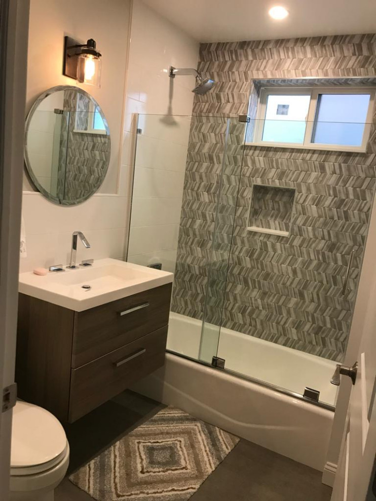 Design ideas for a mid-sized traditional master bathroom in New York with shaker cabinets, dark wood cabinets, an alcove tub, a shower/bathtub combo, gray tile, matchstick tile, an integrated sink, a sliding shower screen, a single vanity and a floating vanity.