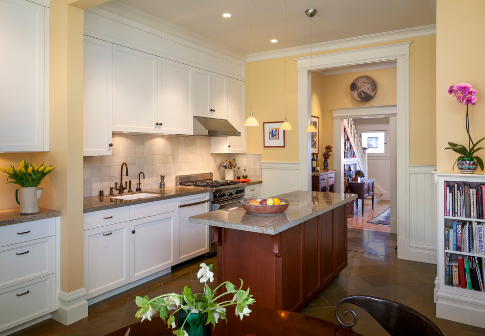 Example of a classic eat-in kitchen design in San Francisco with an undermount sink, shaker cabinets, white cabinets, beige backsplash, stone tile backsplash and stainless steel appliances