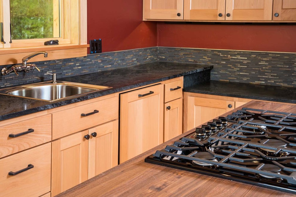 Inspiration for a craftsman light wood floor open concept kitchen remodel with stainless steel appliances, an island, a drop-in sink, light wood cabinets, multicolored backsplash and stone tile backsplash
