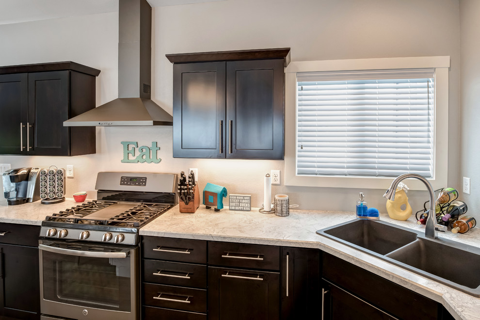 Example of a large transitional l-shaped medium tone wood floor open concept kitchen design with a double-bowl sink, shaker cabinets, dark wood cabinets, quartzite countertops, stainless steel appliances and an island