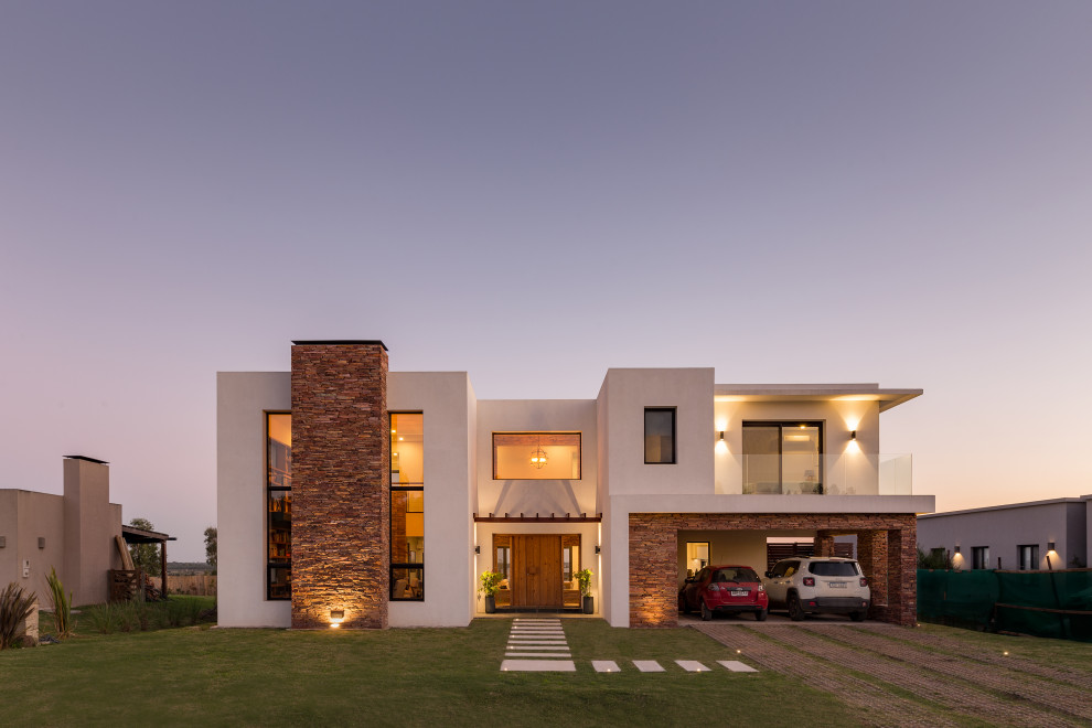 Large modern two-storey white house exterior in Other with stone veneer, a flat roof, a mixed roof and a white roof.