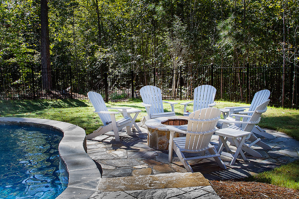 Photo of a mid-sized country backyard custom-shaped natural pool in Raleigh with a hot tub and natural stone pavers.