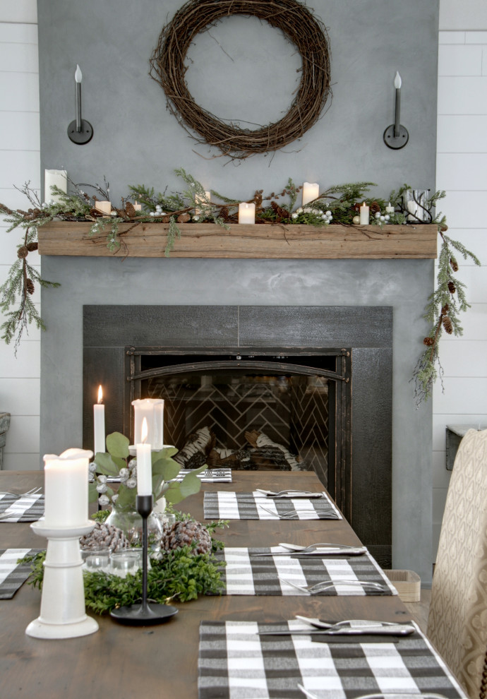 This is an example of a large dining room in Montreal with white walls, a standard fireplace, a concrete fireplace surround and planked wall panelling.