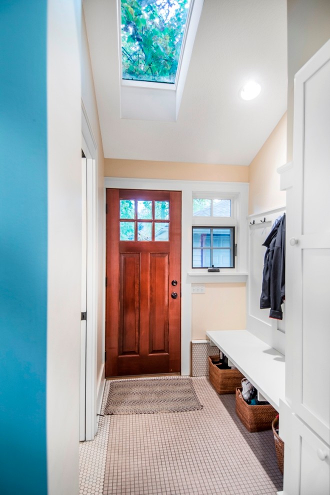 This is an example of a small arts and crafts mudroom in Omaha with yellow walls, ceramic floors, a single front door and a dark wood front door.