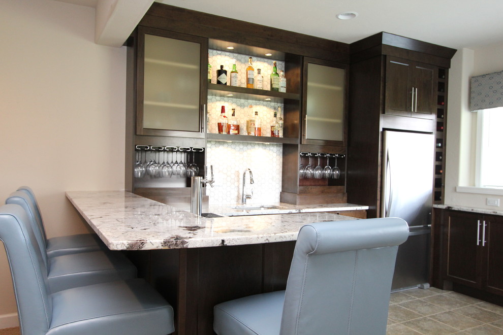 Inspiration for a mid-sized transitional u-shaped seated home bar in Milwaukee with an undermount sink, shaker cabinets, dark wood cabinets, granite benchtops, grey splashback, mosaic tile splashback and travertine floors.