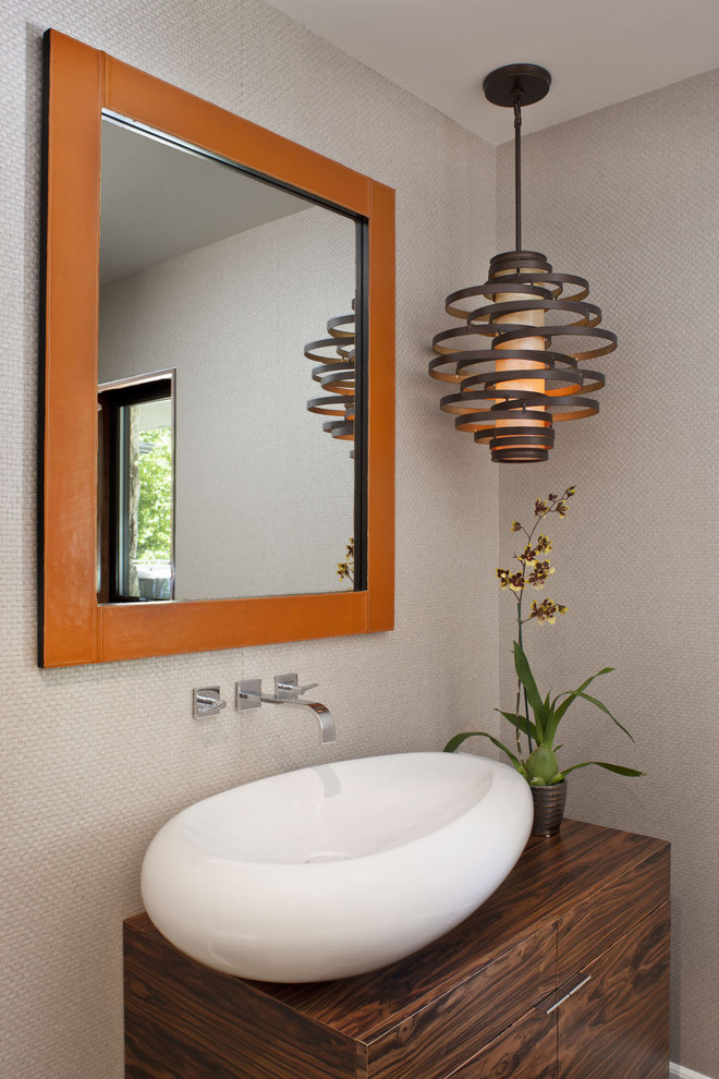 Contemporary powder room in Los Angeles with a vessel sink, flat-panel cabinets, dark wood cabinets and grey walls.