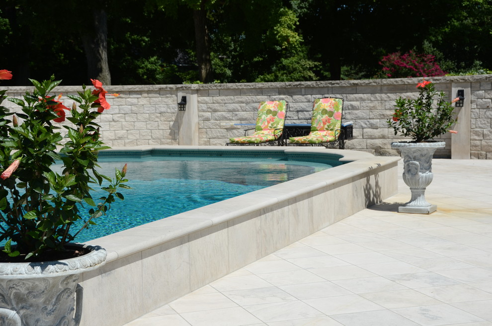 This is an example of a large traditional backyard custom-shaped aboveground pool in Other with natural stone pavers.