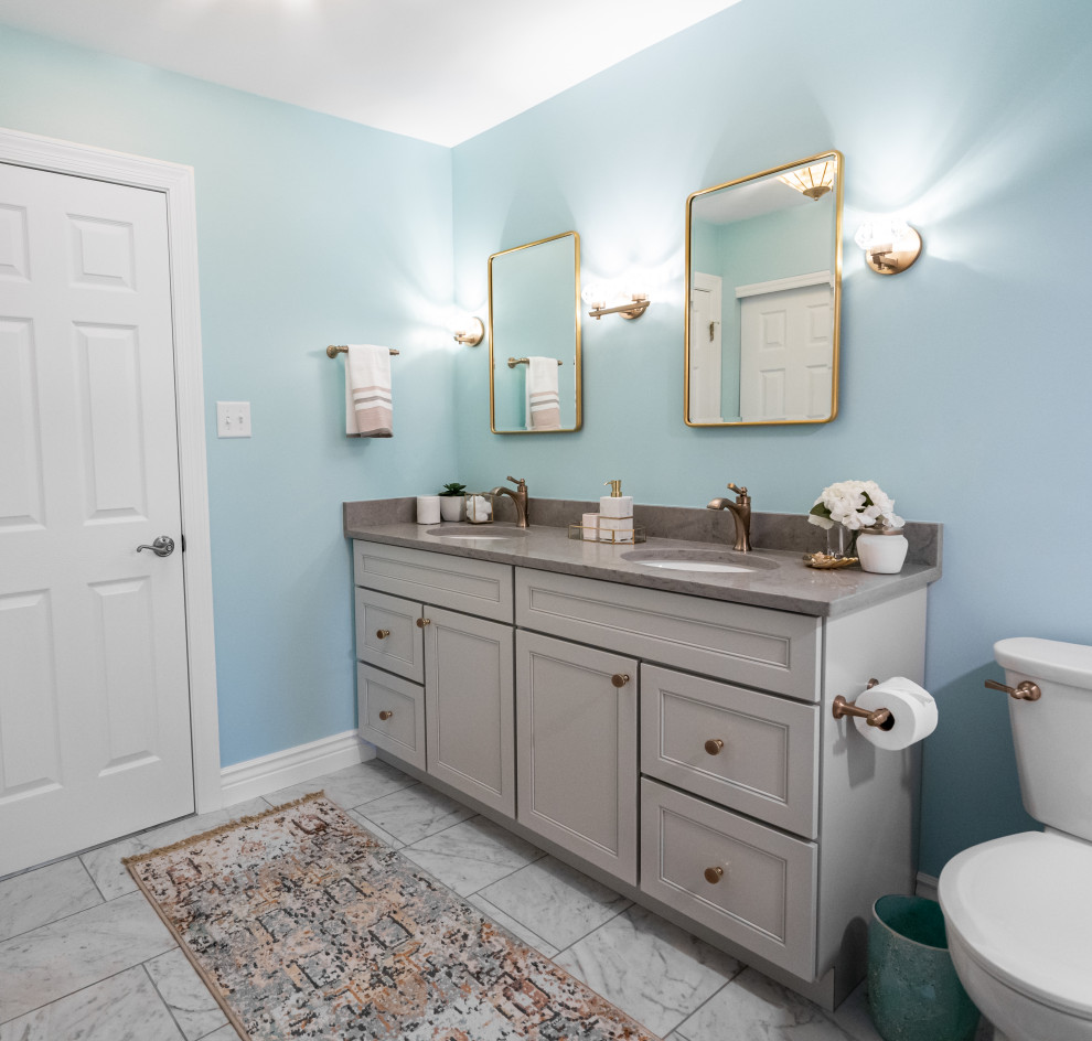 Photo of a mid-sized transitional kids bathroom in St Louis with flat-panel cabinets, grey cabinets, an alcove tub, an alcove shower, a two-piece toilet, multi-coloured tile, ceramic tile, blue walls, porcelain floors, an undermount sink, engineered quartz benchtops, white floor, a shower curtain, grey benchtops, a niche, a double vanity and a built-in vanity.