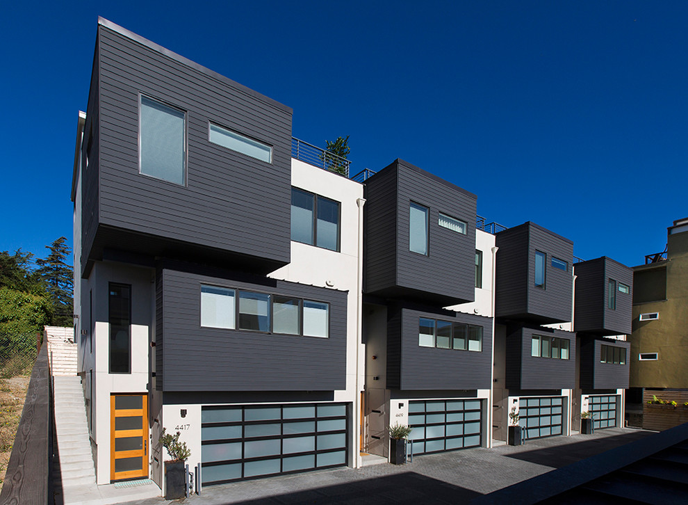 Inspiration for an expansive modern three-storey grey townhouse exterior in San Francisco with mixed siding, a flat roof and a mixed roof.