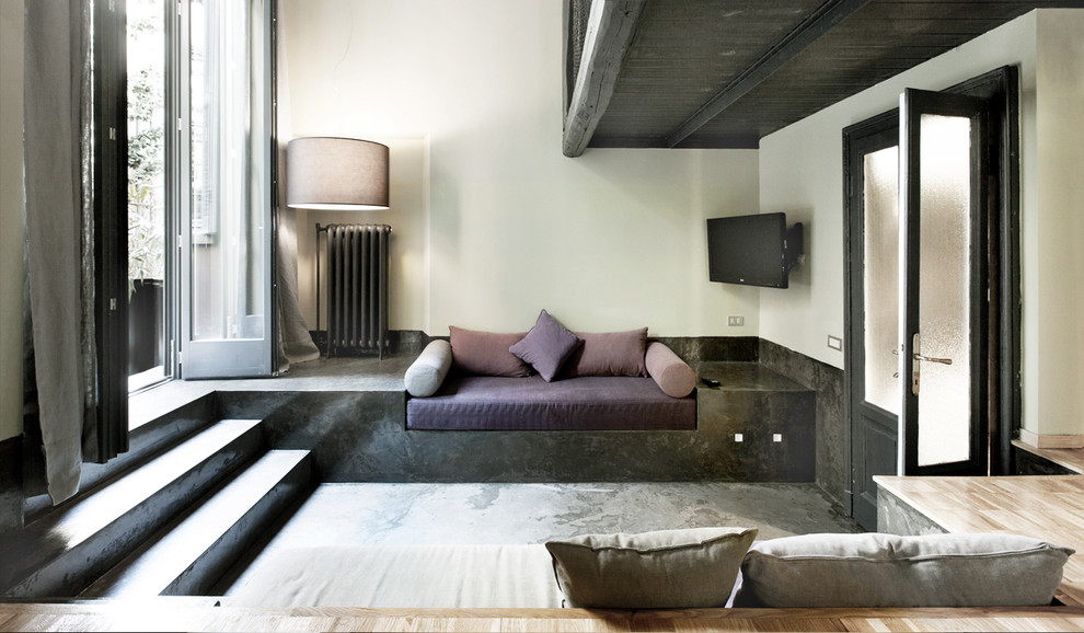Inspiration for a mid-sized industrial enclosed family room in Milan with white walls and a wall-mounted tv.